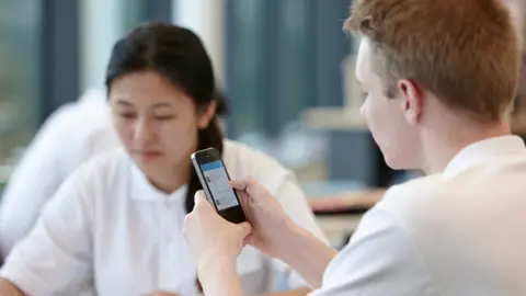 Getty Images schoolchildren using a smartphone in class