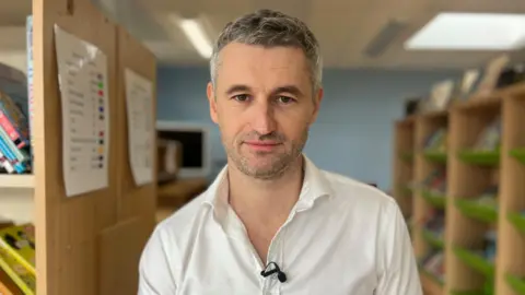 Nicola Haseler/BBC Richard Bowdler wearing a white shirt with short grey hair looking directly at the camera.