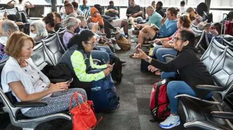 Getty Images People waiting at a departure gate in Austin, Texas in 2022.