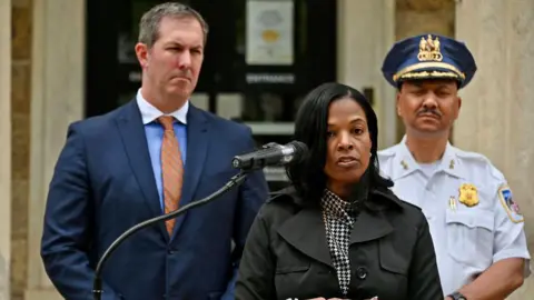 Getty Images Dr Myriam Rogers (centre), superintendent of Baltimore County Public Schools, and Police Chief Robert McCullough (right) speak at a press conference