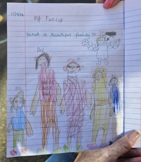 Kate Jennings A hand-drawn child's picture of a family including a baby in heaven