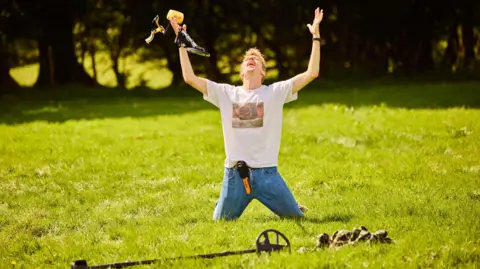 FremantleMedia Ltd/Naked West Charlie Cooper in a field with metal detector equipment