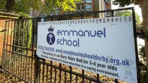 Picture of a sign outside Emmanuel School in Derby showing that it's a Christian school and accepts children as young as three.