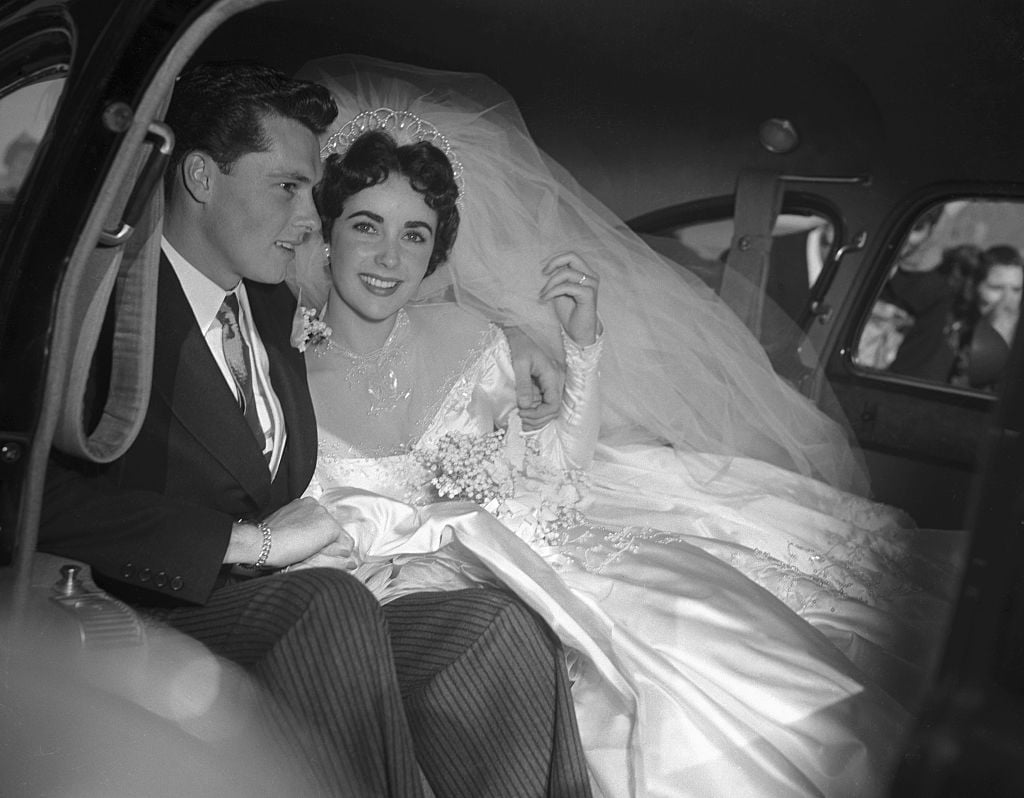 Actress Elizabeth Taylor and her groom, Conrad "Nickie" Hilton, Jr. in the limousine that will take them to their wedding reception at the Bel-Air Country Club, following their marriage at the Church of the Good Shepherd in Beverly Hills. Getty Images