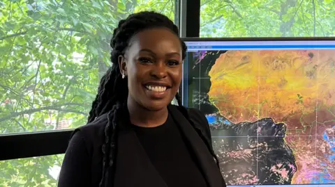 Sarah Kimani Sarah Kimani, of the Kenyan Meteorological Department, stands in front of a meteorological map.