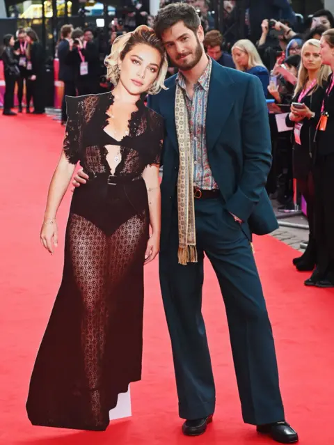 Getty Images Andrew Garfield (R) poses with a cardboard cutout of Florence Pugh at the Headline Gala screening of "We Live In Time" during the 68th BFI London Film Festival at The Royal Festival Hall on October 16, 2024 in London, England