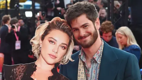 Getty Images Andrew Garfield (R) poses with a cardboard cutout of Florence Pugh at the Headline Gala screening of "We Live In Time" during the 68th BFI London Film Festival at The Royal Festival Hall on October 16, 2024 in London, England