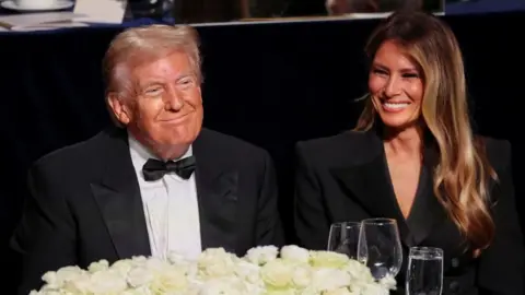 Reuters Donald and Melania Trump smile at a charity event