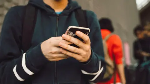 Getty Images A boy holding a mobile phone.